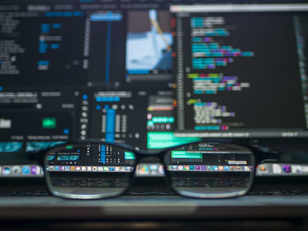Image of computer code on a screen with glasses in front